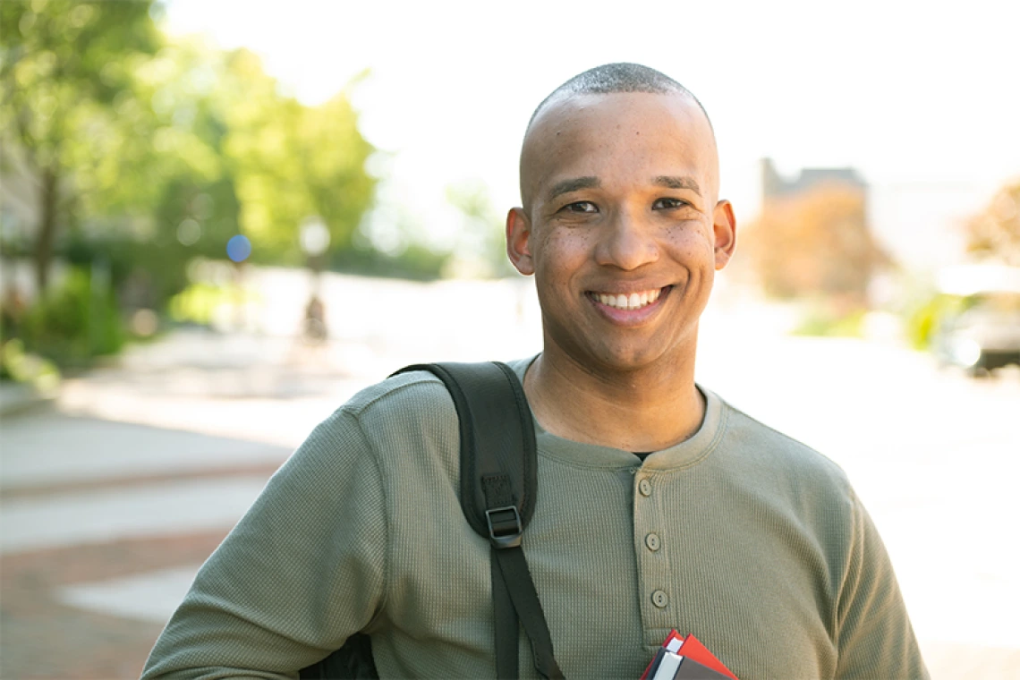 Person smiling while posing for an outdoor portrait