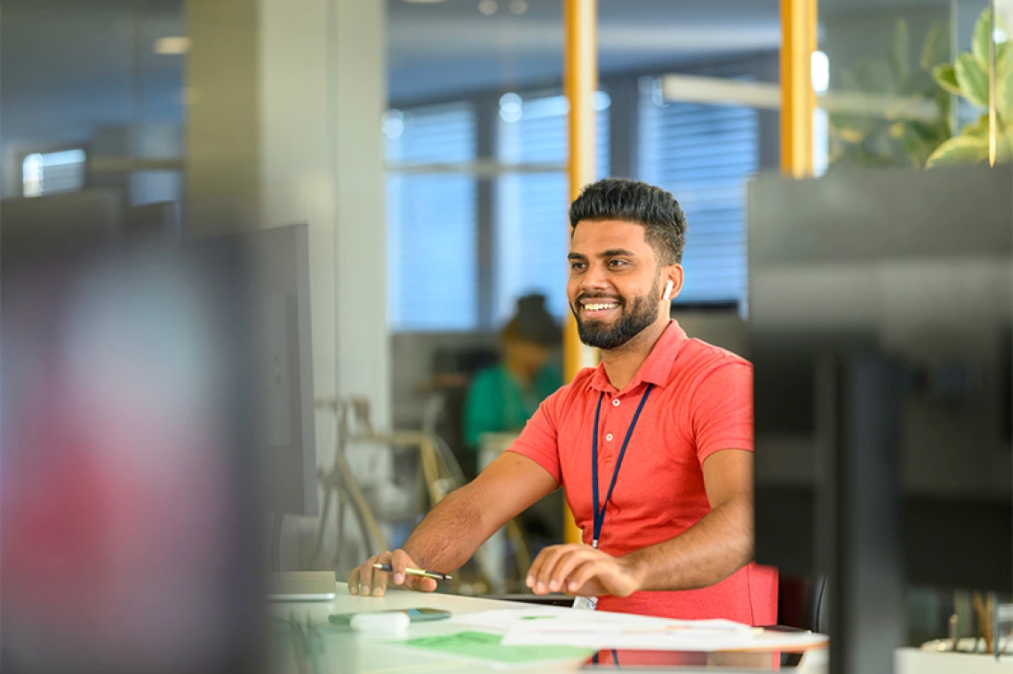Person smiling while working on the computer