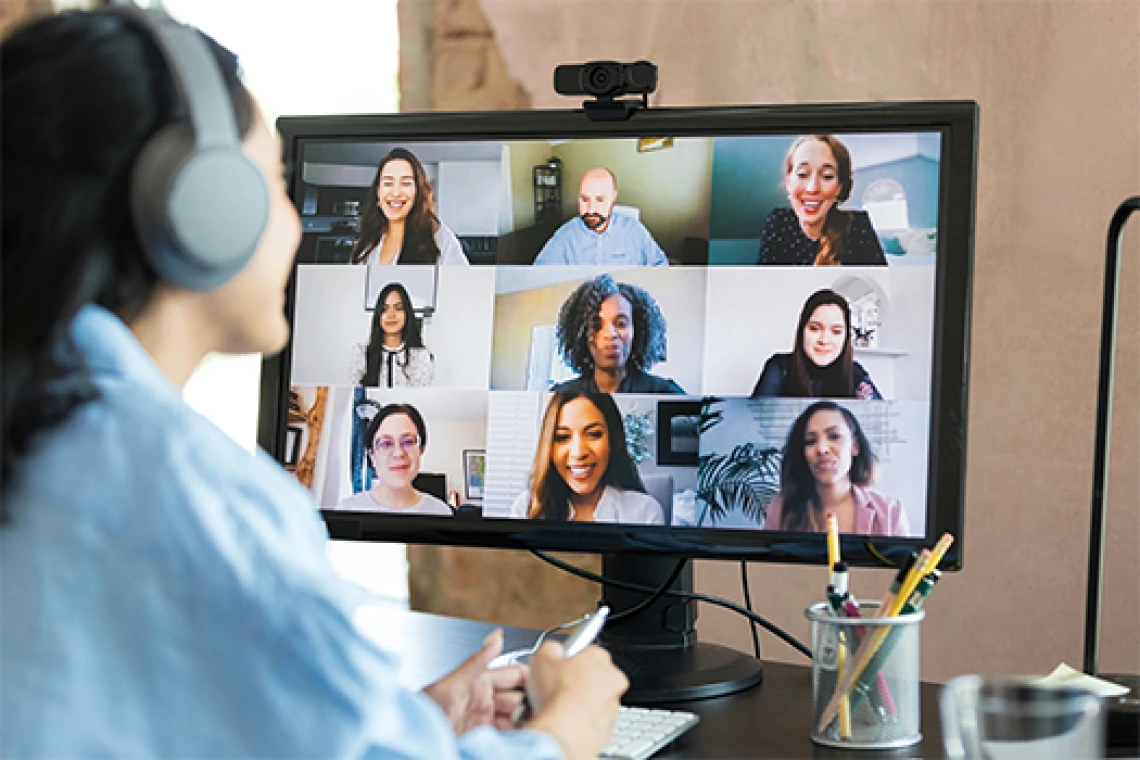 Student wearing headphones sits on a zoom call with a group of people